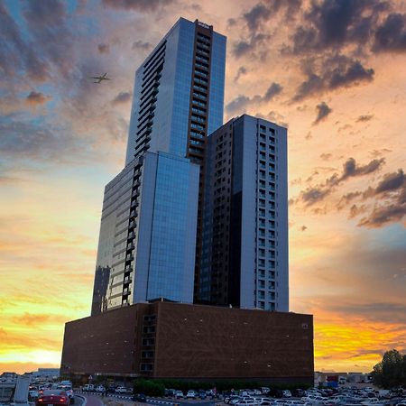 שארג'ה Luxe Grand Hotel Apartments מראה חיצוני תמונה The building at sunset