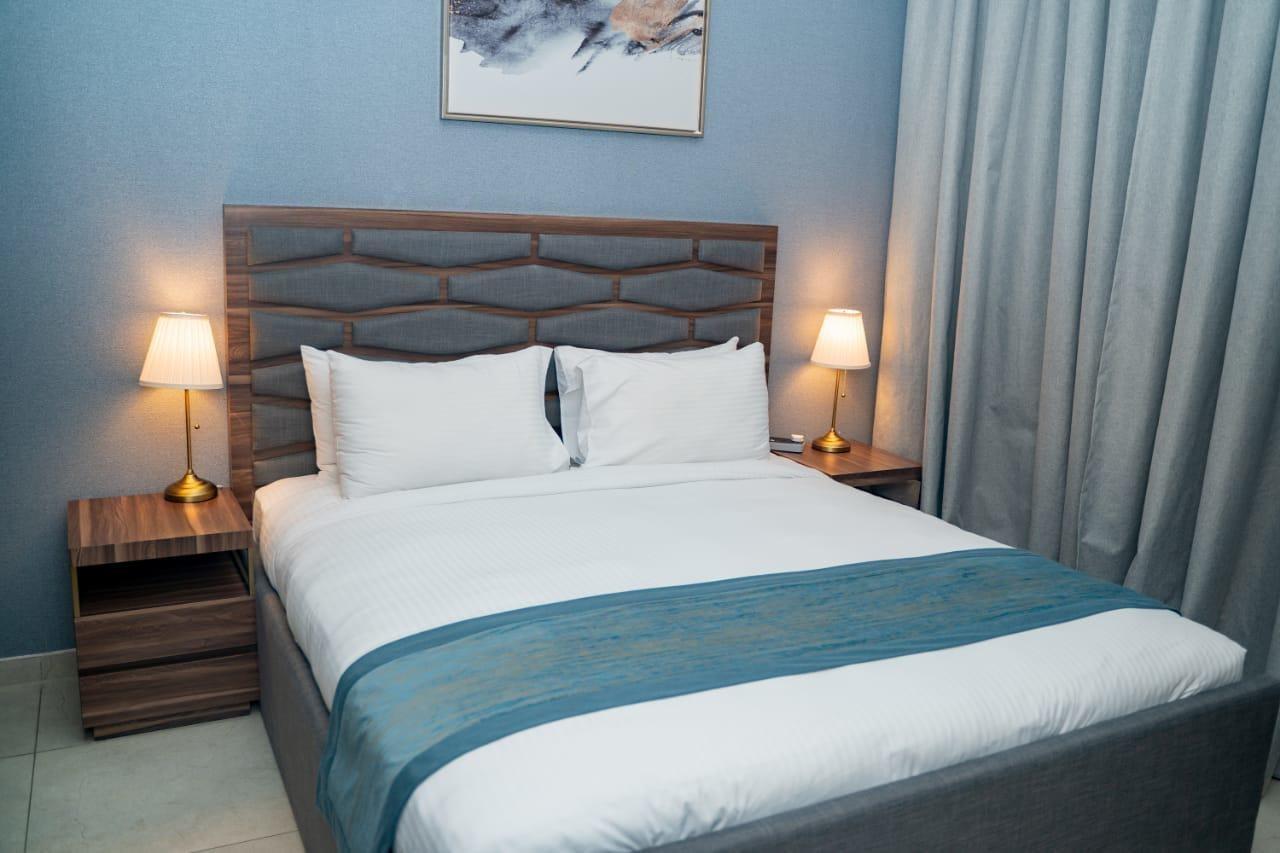 שארג'ה Luxe Grand Hotel Apartments מראה חיצוני תמונה A bed with a bed runner